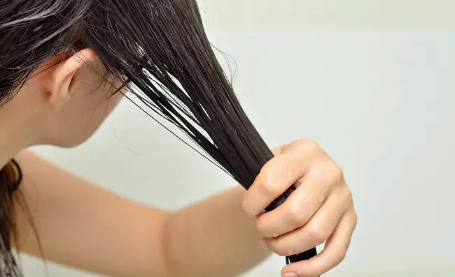 Femme effectuant un traitement avec des masques pour les cheveux abîmés