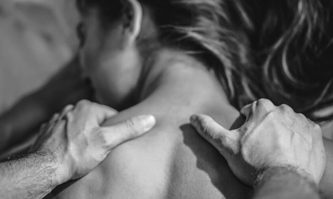 mujer recibe masaje de su pareja