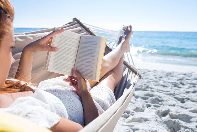 mujer leyendo en la playa