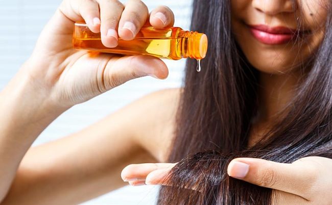 Mujer usando aceite de oliva para tratar su cabello