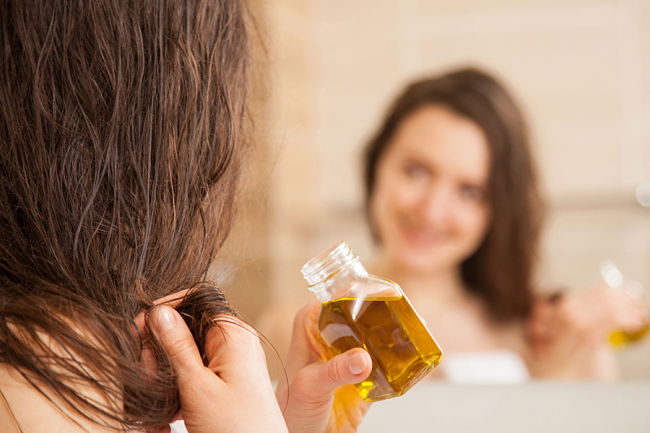 Mujer aplicando aceite de germen de trigo en su cabello