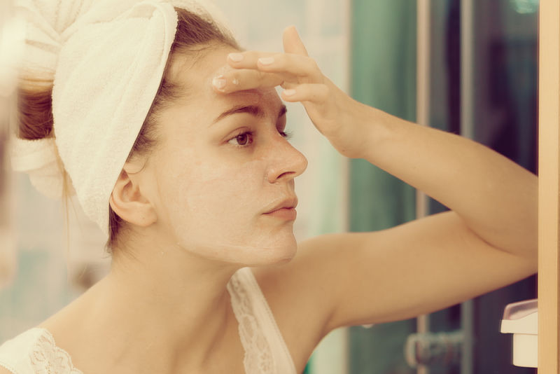 mujer joven aplicando crema por un problema de resequedad en la piel