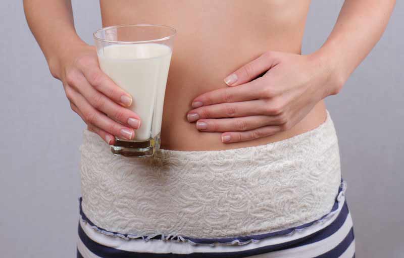 Mujer que presenta síntomas de alergia a la leche de vaca