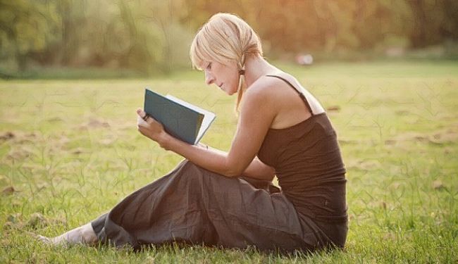 Una mujer leyendo frases y pensamientos positivos en un libro