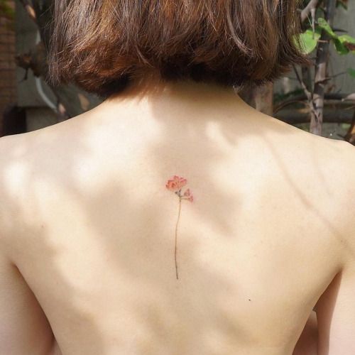 Uma menina com uma tatuagem de flores nas costas