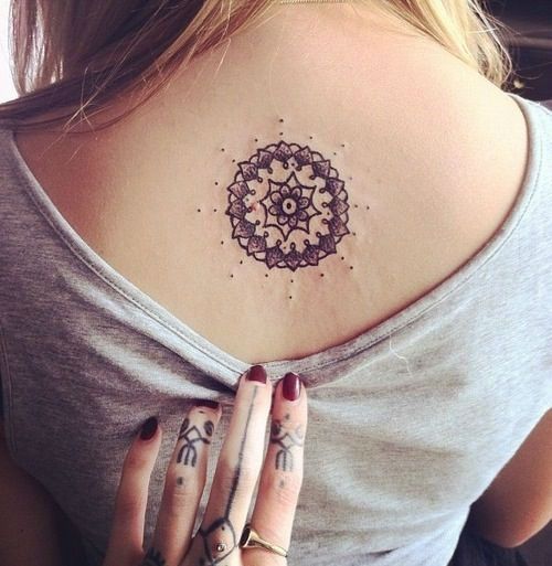 Jovem garota vestindo uma tatuagem em forma de mandala nas costas