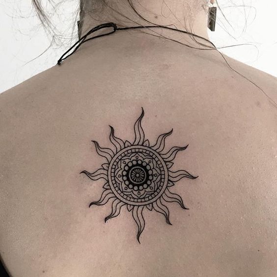 La forma de un sol como un tatuaje en la espalda