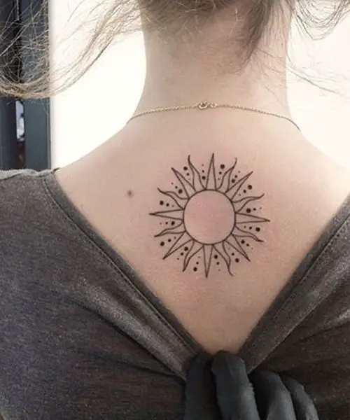 Um sol tatuado nas costas