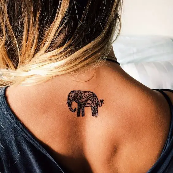 Un elefante mediano tatuado entre los omóplatos en la espalda