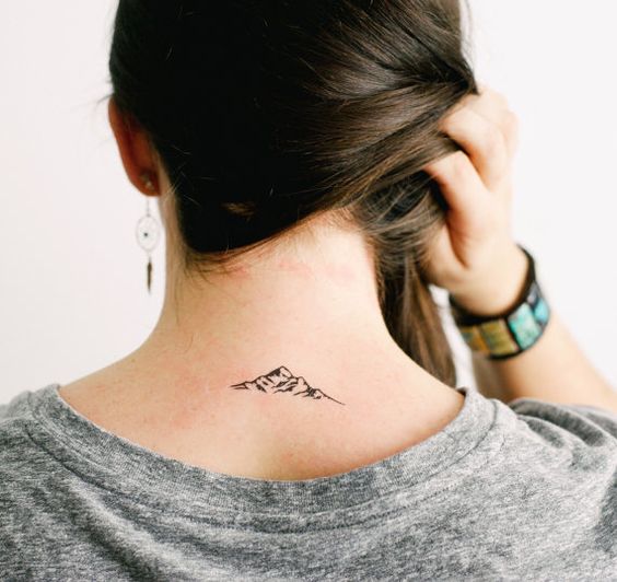 Uma garota com uma pequena montanha tatuada nas costas