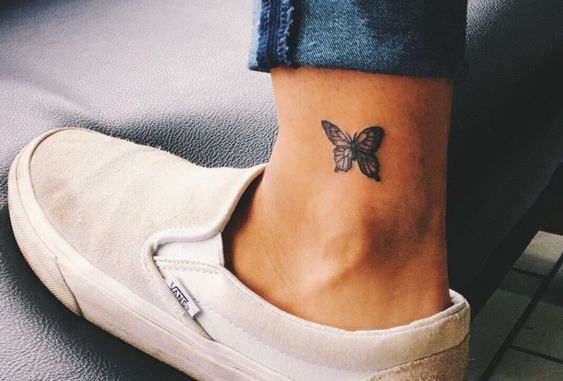 un tatuaje pequeño de una mariposa cerca del tobillo