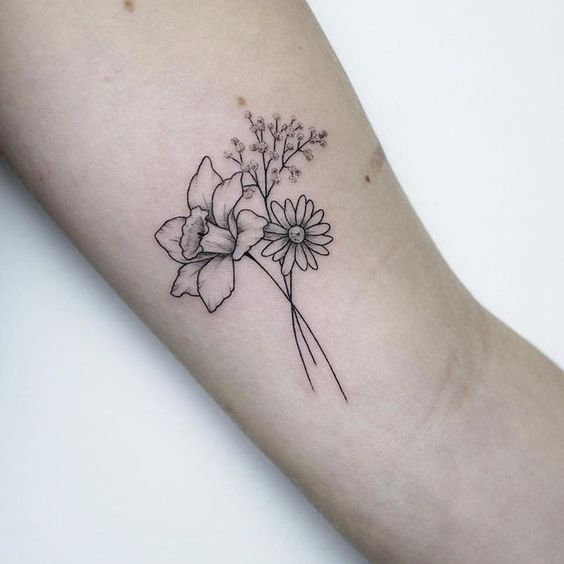 Un conjunto de flores tatuadas en el brazo