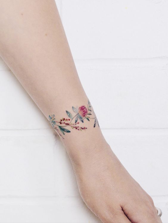 flores tatuadas alrededor de la muñeca