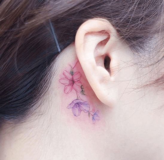 Pequeña rosa tatuada detrás de la oreja