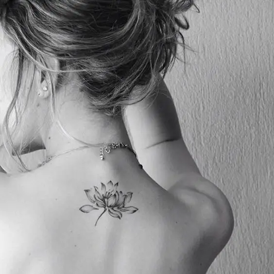 Una flor elegante tatuada en la espalda de una mujer