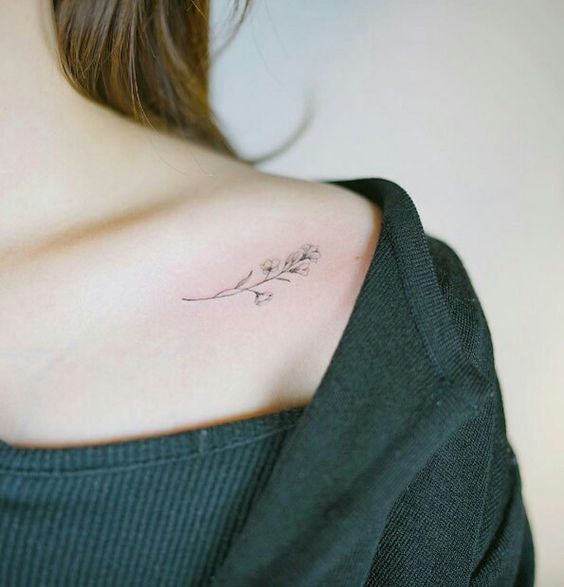 Una chica que lleva un tatuaje de flores en su hombro derecho
