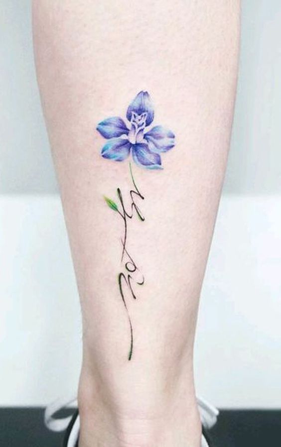 Flor de color azul tatuada en la parte baja de la pierna