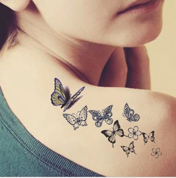varias mariposas tatuadas en la espalda y hombro de una mujer