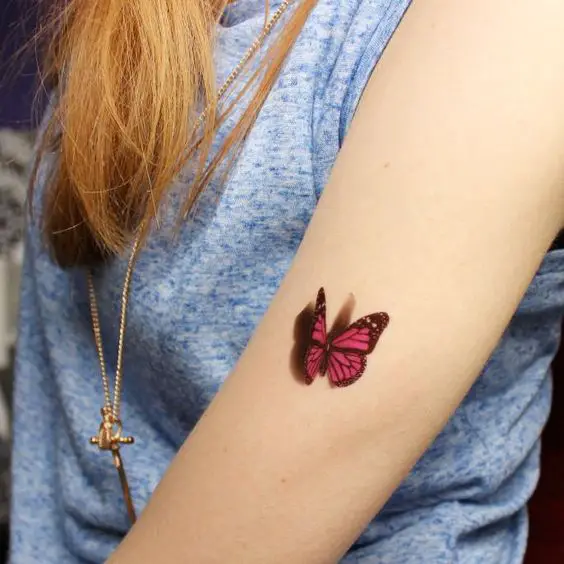 mariposa en 3d de color rojo tatuada en el brazo