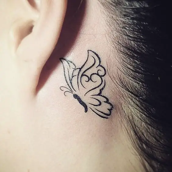 mariposa tribal grande tatuada detrás de la oreja