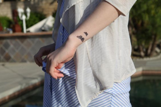 Tatuaje de una mariposa en el brazo izquierdo cerca de la muñeca