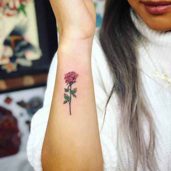 Tatuaje de rosa de color rosa en el antebrazo