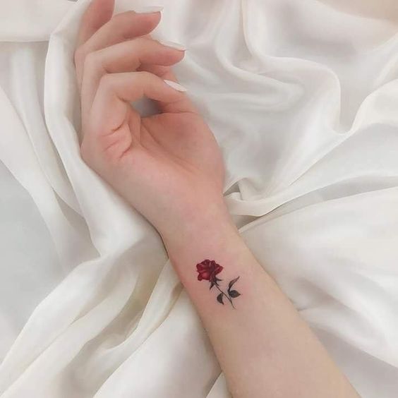 Un tatuaje de una rosa roja en el brazo