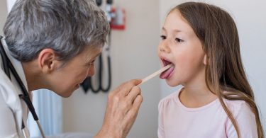 Niña que presenta las amígdalas agrandadas o tonsilitis hipertrófica