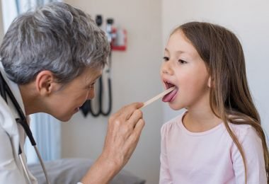 Niña que presenta las amígdalas agrandadas o tonsilitis hipertrófica