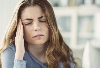 Mujer que sufre migraña y dolores de cabeza