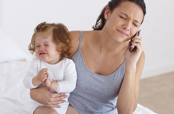 Mamá estresada con hija. Mamás necesitan vacaciones para ellas.