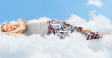 Mujer durmiendo sobre nube. Mujeres necesitan dormir más tiempo.
