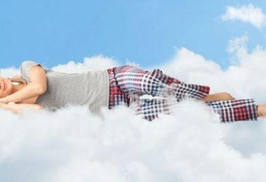 Mujer durmiendo sobre nube. Mujeres necesitan dormir más tiempo.