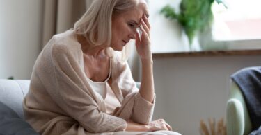 Mujer que padece síntomas de menopausia y requiere una dieta para aliviar los sofocos