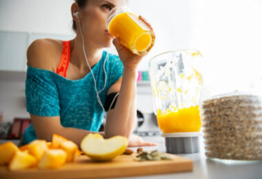Mujer que hace deporte tomando jugo de naranja