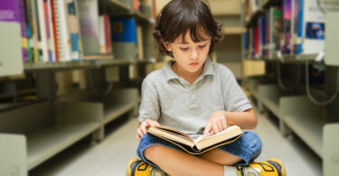 Nene leyendo en la biblioteca