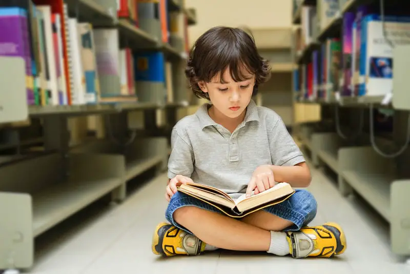 Nene leyendo en la biblioteca