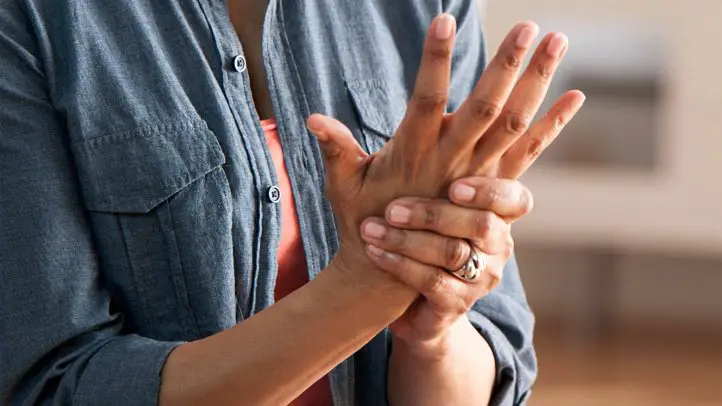 Mujer con dolor en la articulación de la mano