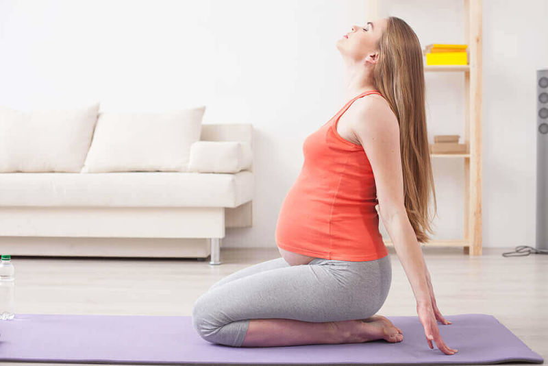 Mujer embarazada haciendo ejercicio de pilates