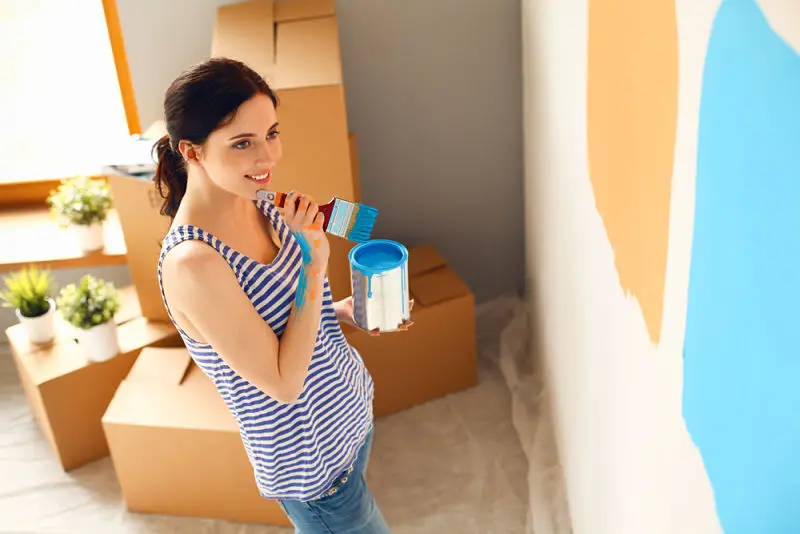 Mujer pintando su casa