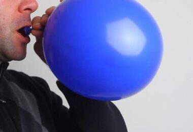 Hombre inflando globo