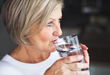 Mujer bebiendo agua para prevenir la osteoporosis