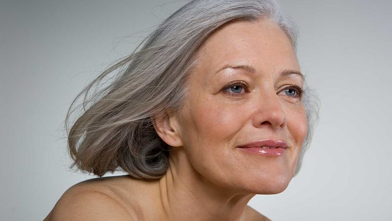 Mujer mayor de 50 años que come ciruelas para prevenir la osteoporosis