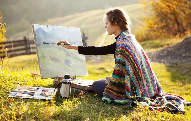 Mujer pintando un cuadro y realizando una obra de arte