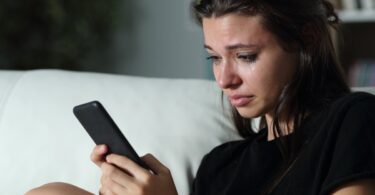 Mujer llorando al bloquar a su ex en las redes sociales