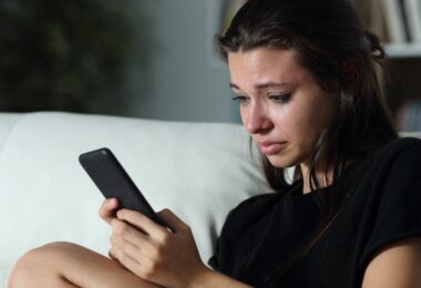 Mujer llorando al bloquar a su ex en las redes sociales