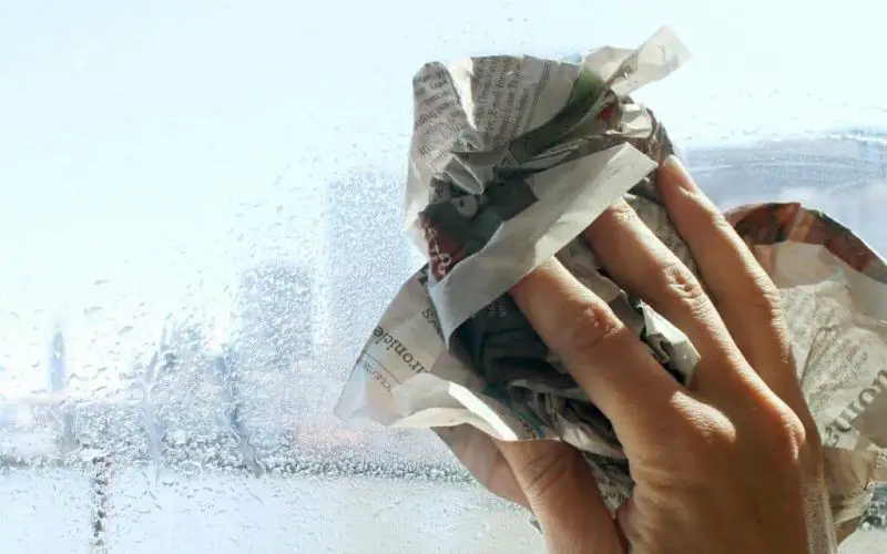 Usando periódico para limpiar el vidrio