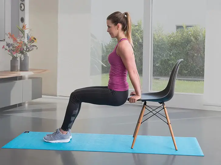 Mujer haciendo ejercicio para brazos usando una silla