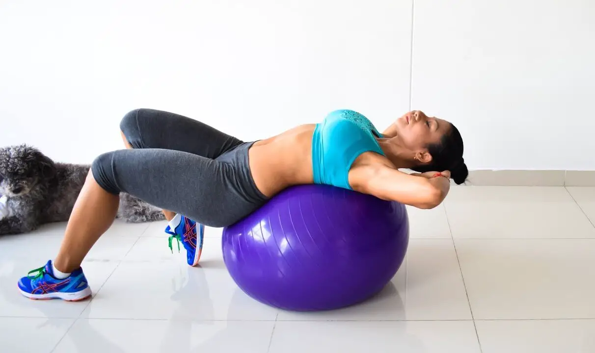 Mujer haciendo concentración abdominal sobre pelota