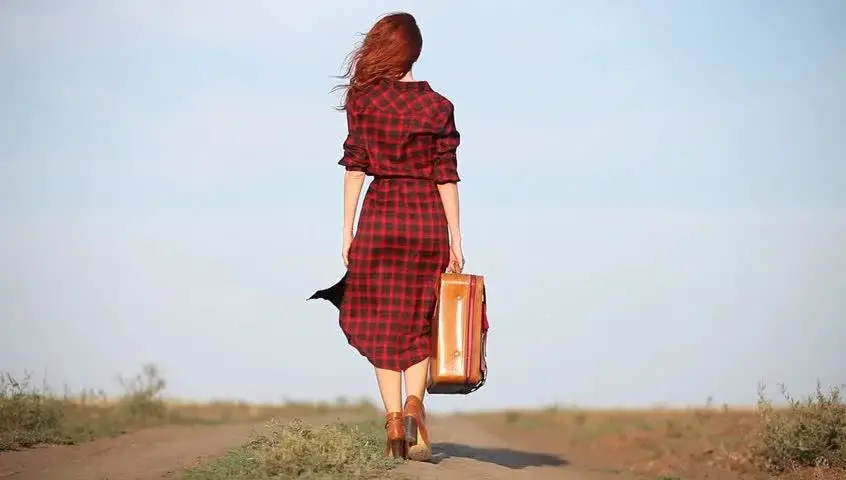 Mujer caminando con su maleta